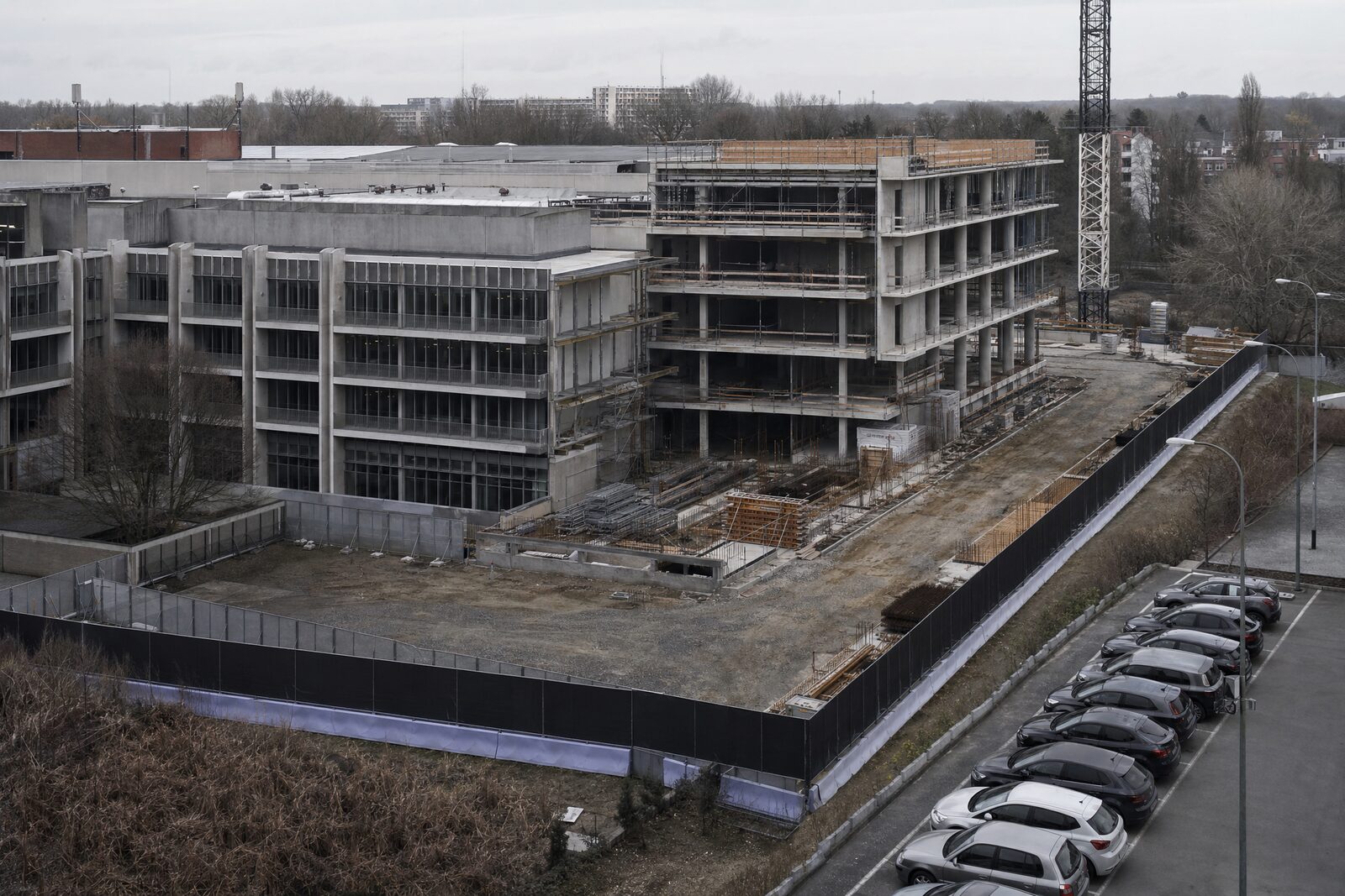 Afgebakende werfzone met een aparte werfweg naast een gebouw dat gewoon in gebruik blijft