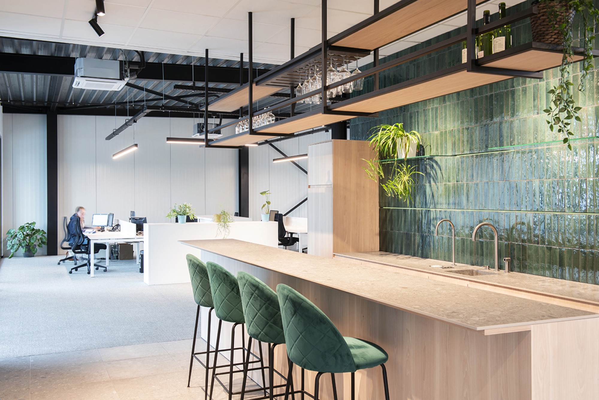 Inkombar bij Helbig met een houten toog, groene krukken, een groene tegelwand en een hangend rek boven de bar
