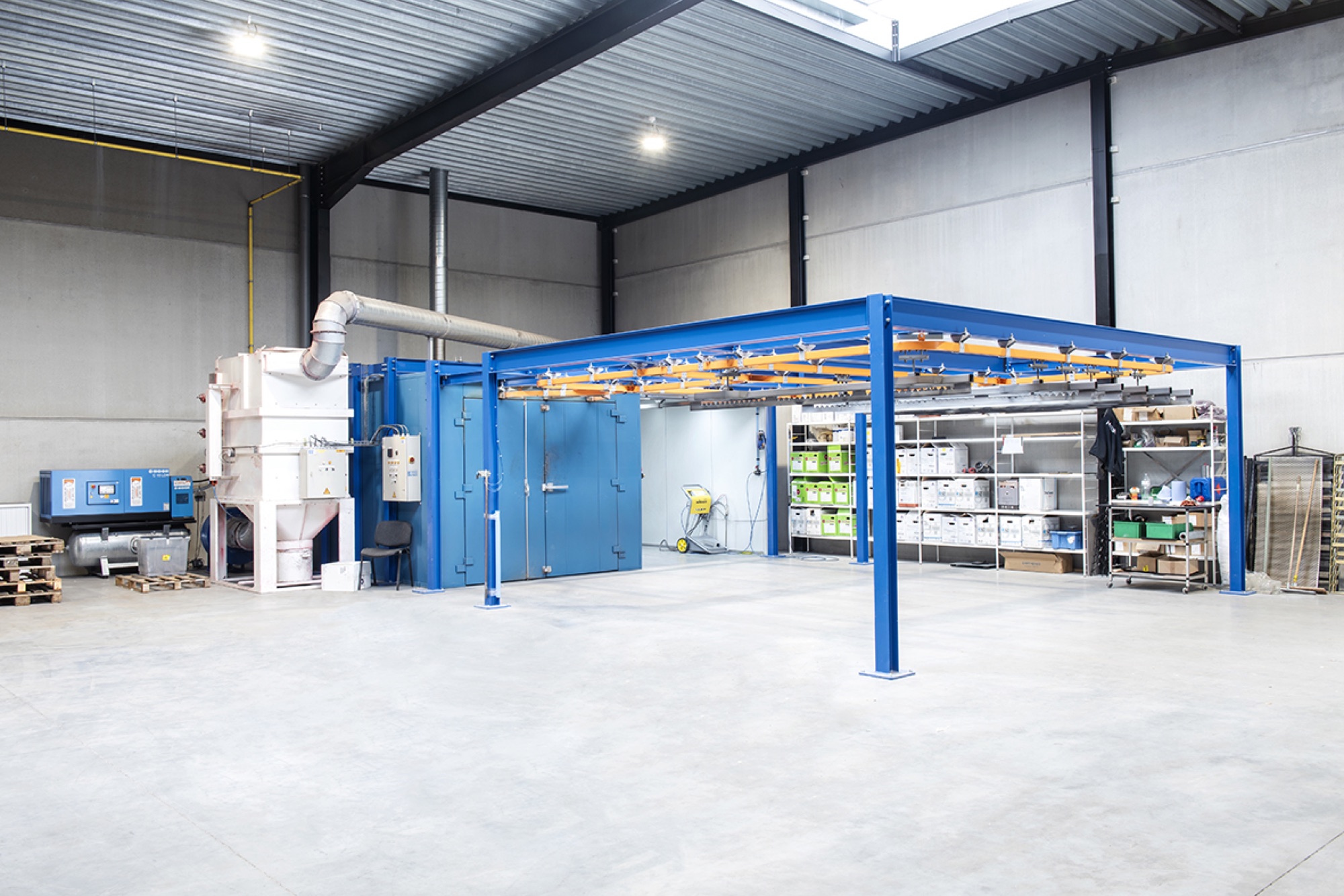 Magazijn van Helbig met een blauwe stalen structuur, blauwe wanden, rekken en een lichtstraat in het dak
