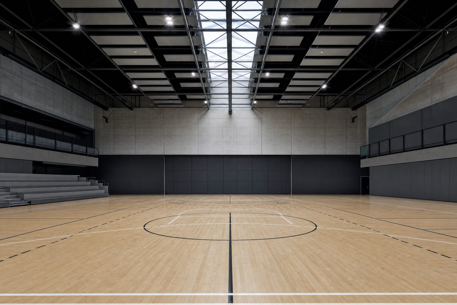 Lege sporthal vanaf vloerhoogte met sportvloer, ingeschoven tribune en hoge vrije ruimte boven het speelveld